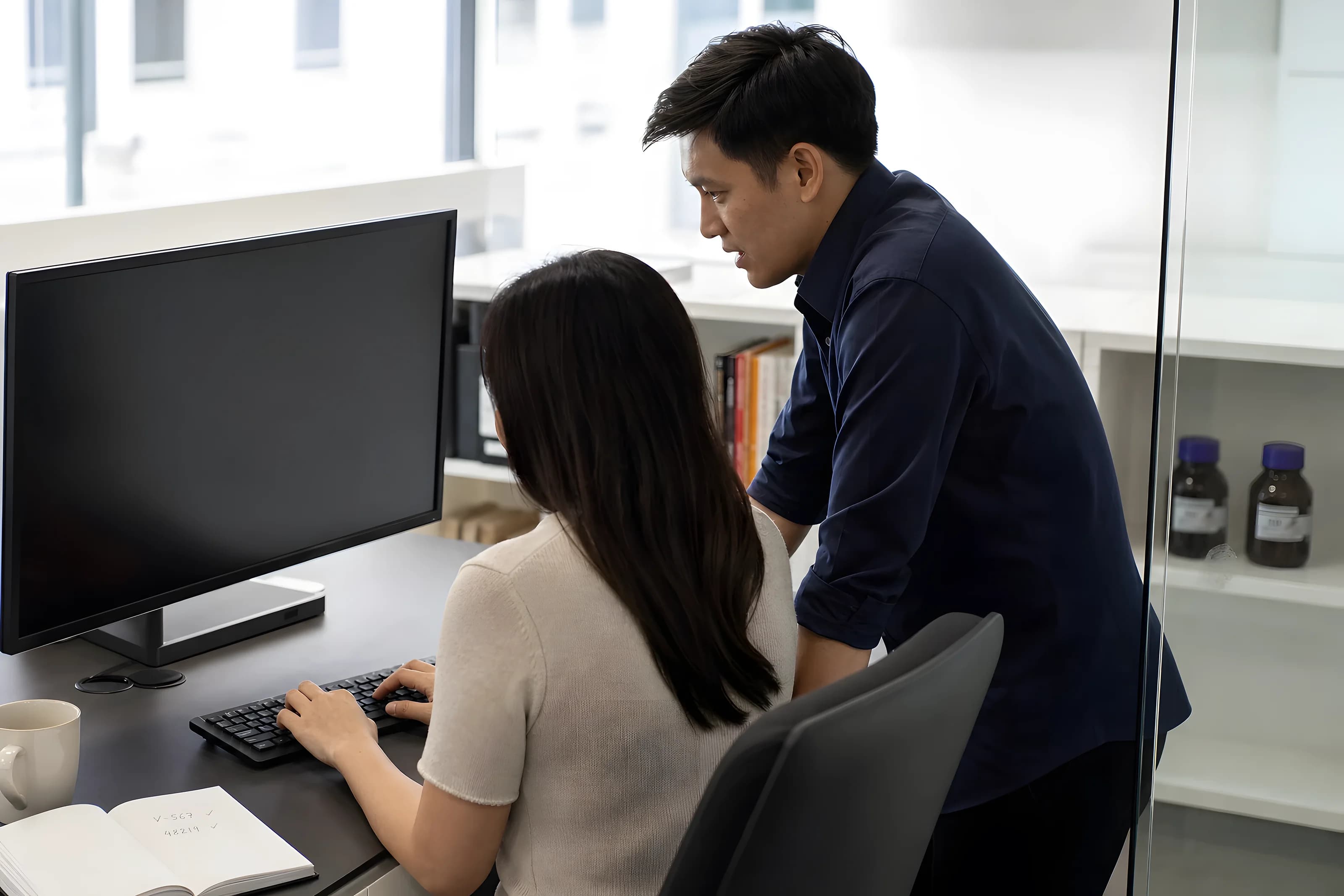 Two VKA colleagues reviewing work together at a monitor